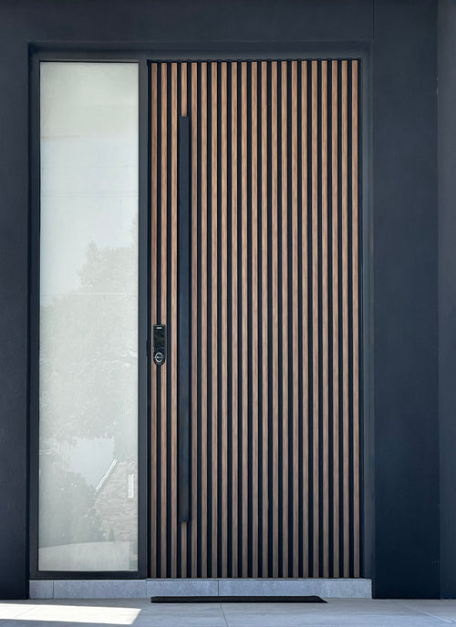 Matt black 1500mm entry door pull handle set on a dark background, featuring a slatted timber door 