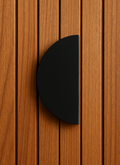 Black half-moon pull handle on a timber door