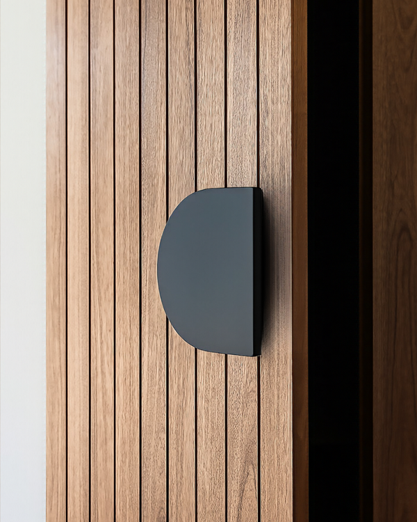 A matte black D Plate 220 Pull Handle on a vertical timber slat door