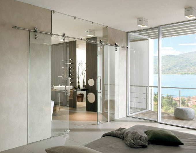 Modern bathroom with glass shower enclosure and large windows overlooking a scenic view.