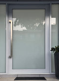stainless steel offset pull handle on a modern entry door with a brushed stainless finish. 