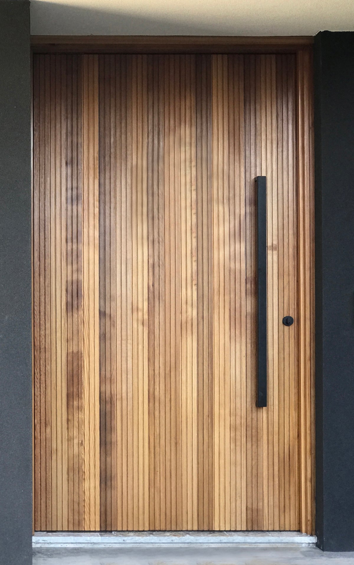 Wooden slatted door with a black 900mm entry door handle 