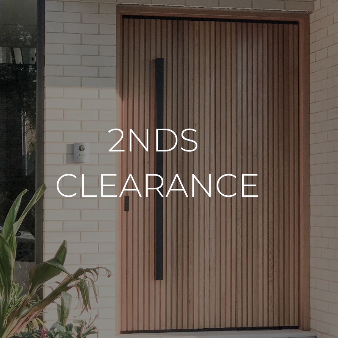 A brown wooden entry door with a matt black handle featuring the text '2NDS CLEARANCE' indicating a second-hand clearance offer.