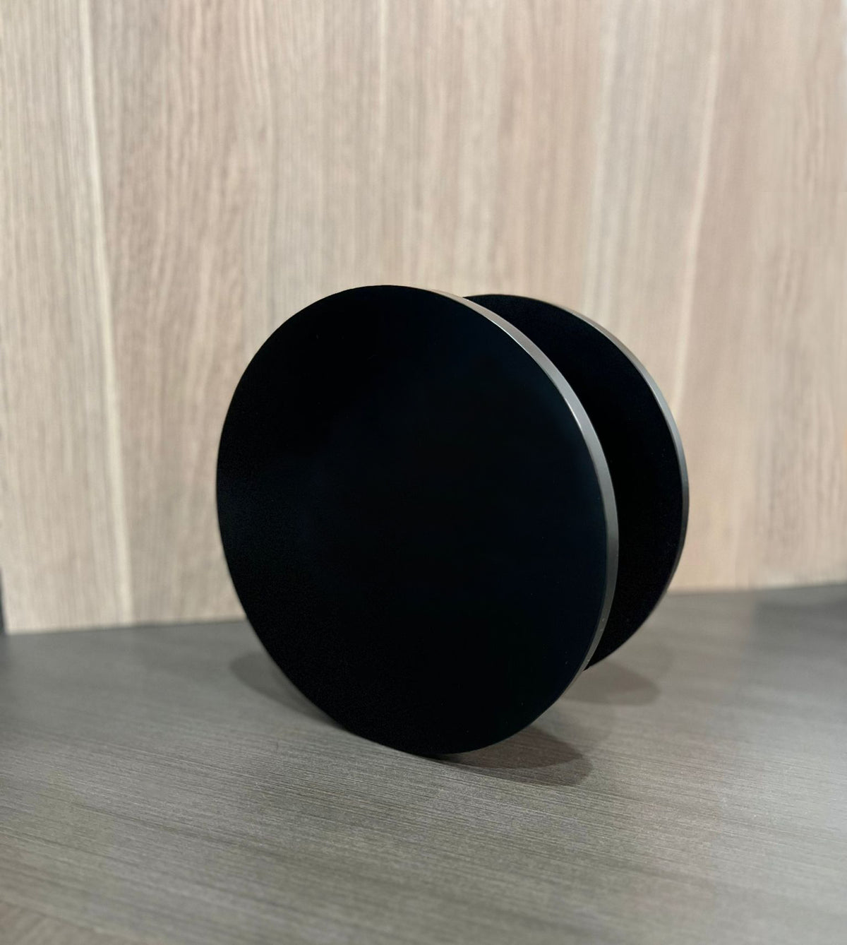 Pair of matt black round Rhondo 220 entry door pull handles viewed from the front on a diagonal